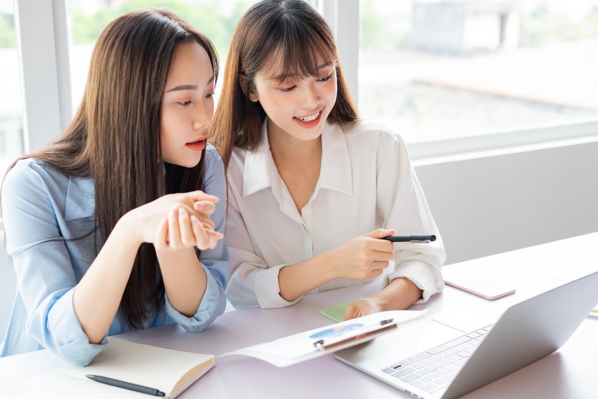 Asian Businesswoman and Colleagues Discussing Work Together